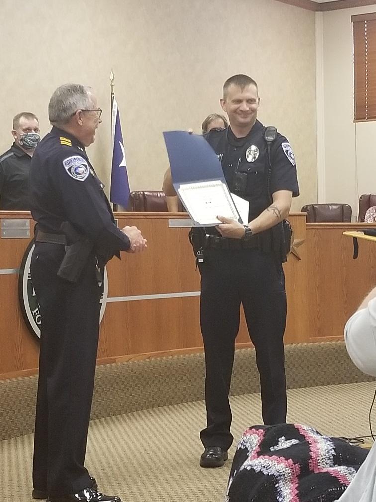 Police Officer Holding up a Certificate